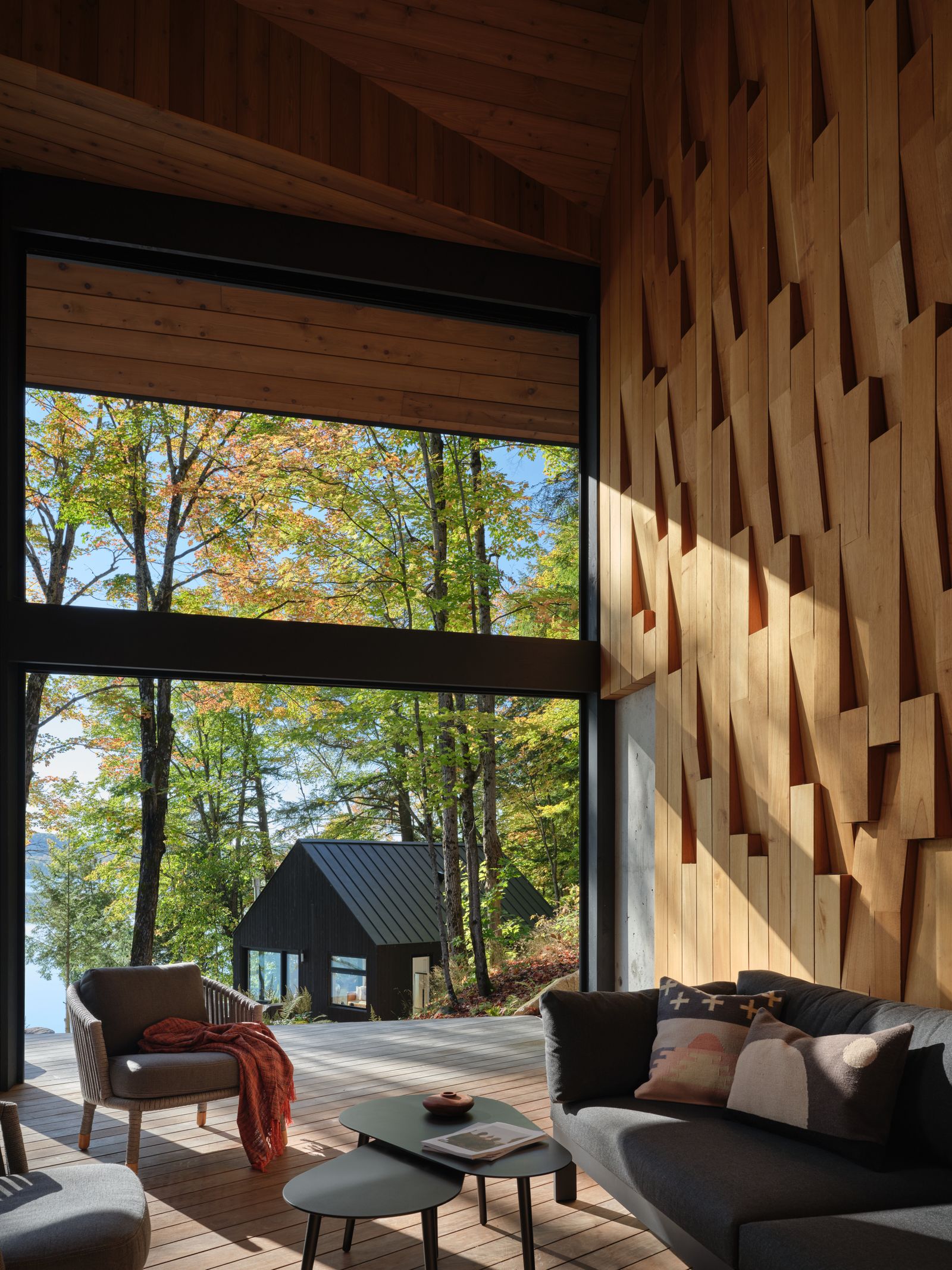 halboffene Veranda mit strukturierter Zedernholzwand Sessel Sofa Seeblick