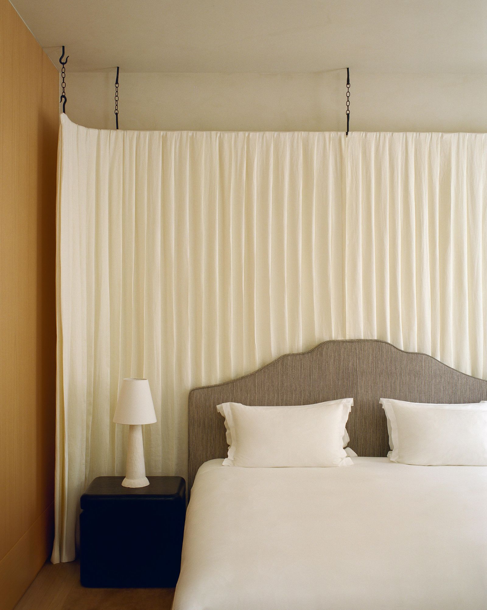 Renovierung in Paris Schlafbereich mit Bett Nachtischen und Vorhang