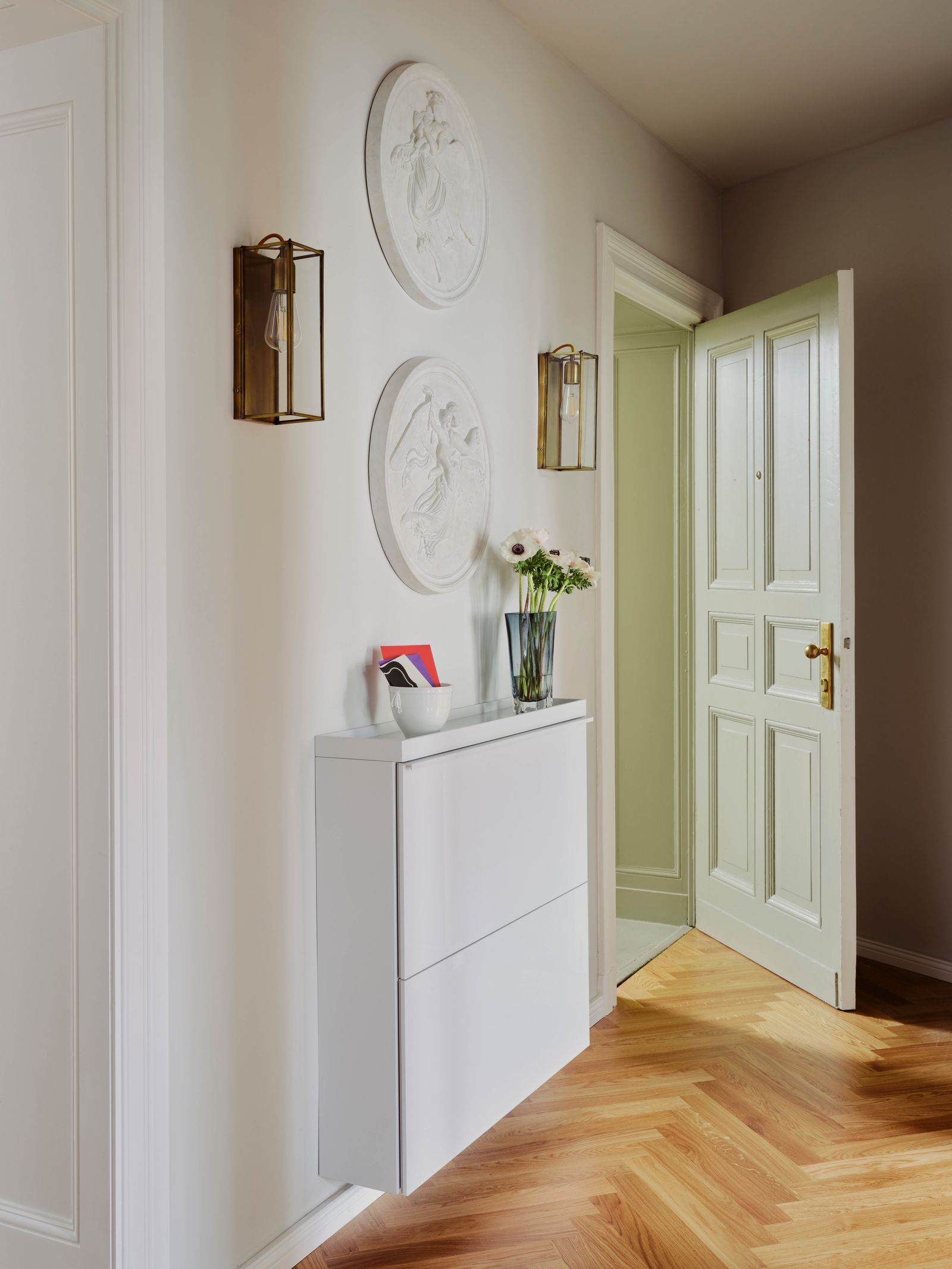 Eingangsbereich mit Sideboard und Dekoration an der Wand in einer Berliner Altbauwohnung