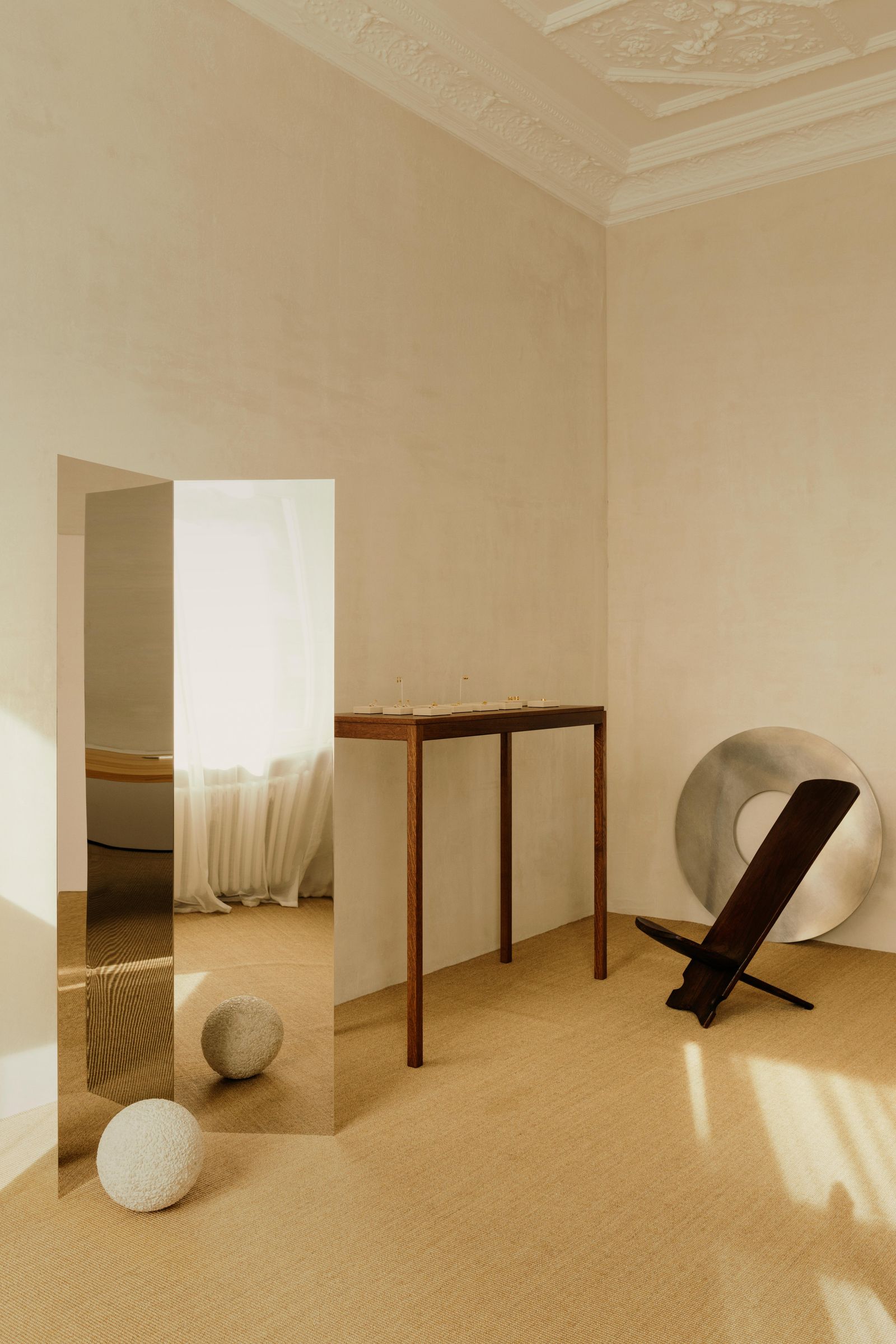 Im Showroom von Golpira findet sich ein „Pose Mirror“ von Forever Studios. Rechts steht ein afrikanischer Palaver Chair.