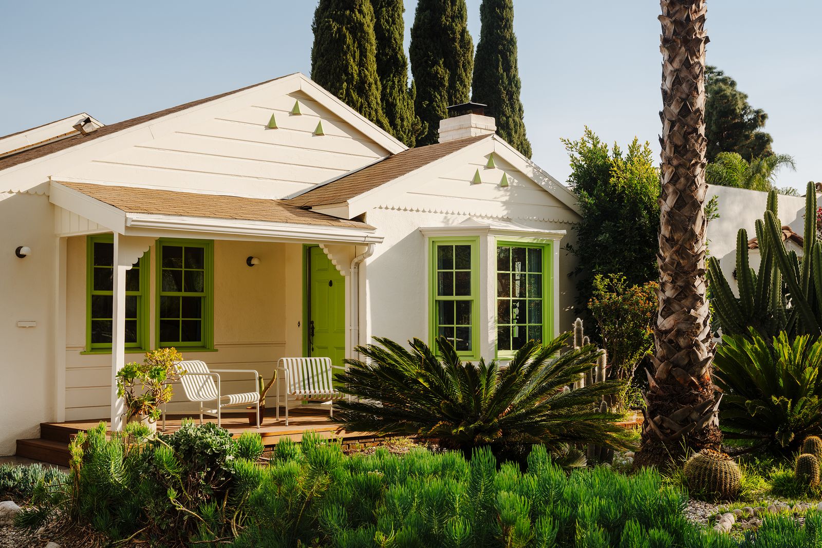 Weißes Wohnhaus aus Holz grüne Fenster Veranda Garten