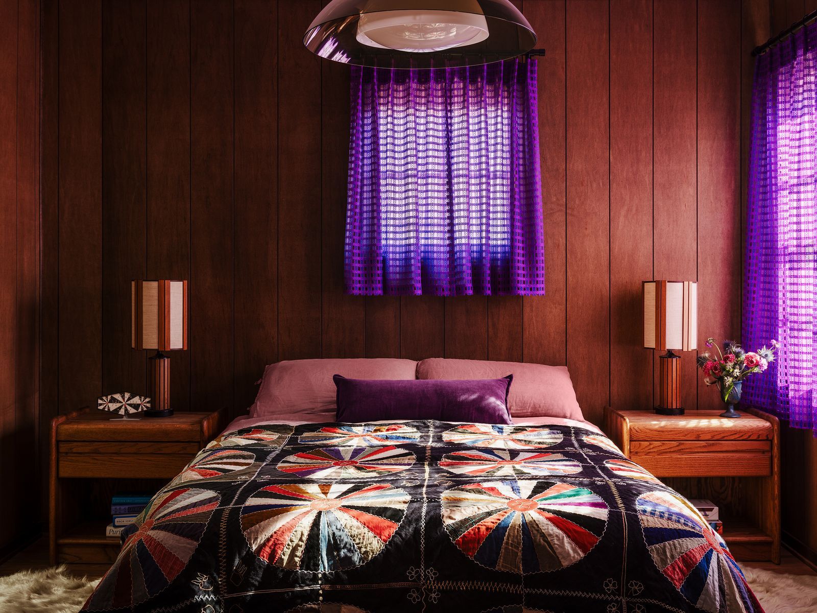 Schlafzimmer in Braun und Rostönen Holzvertäfelung lilafarbene Vorhänge