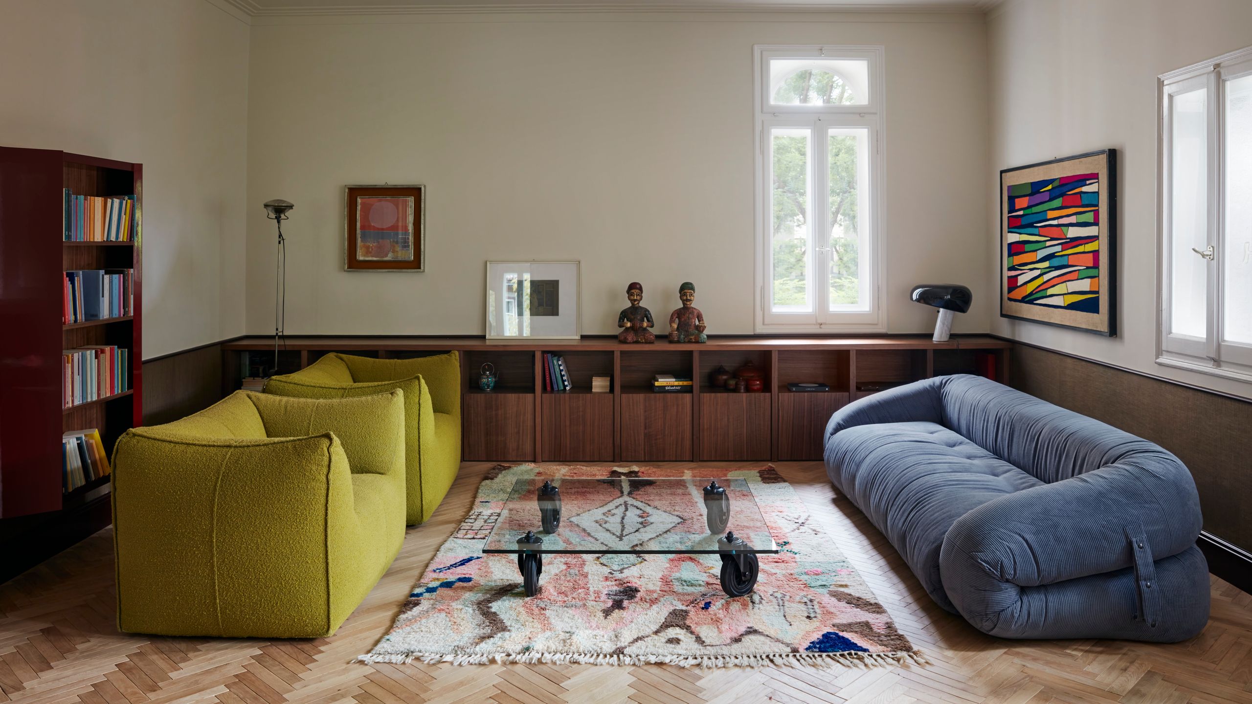 Wohnzimmer mit blauem Sofa und zwei schwefelgelben Sesseln