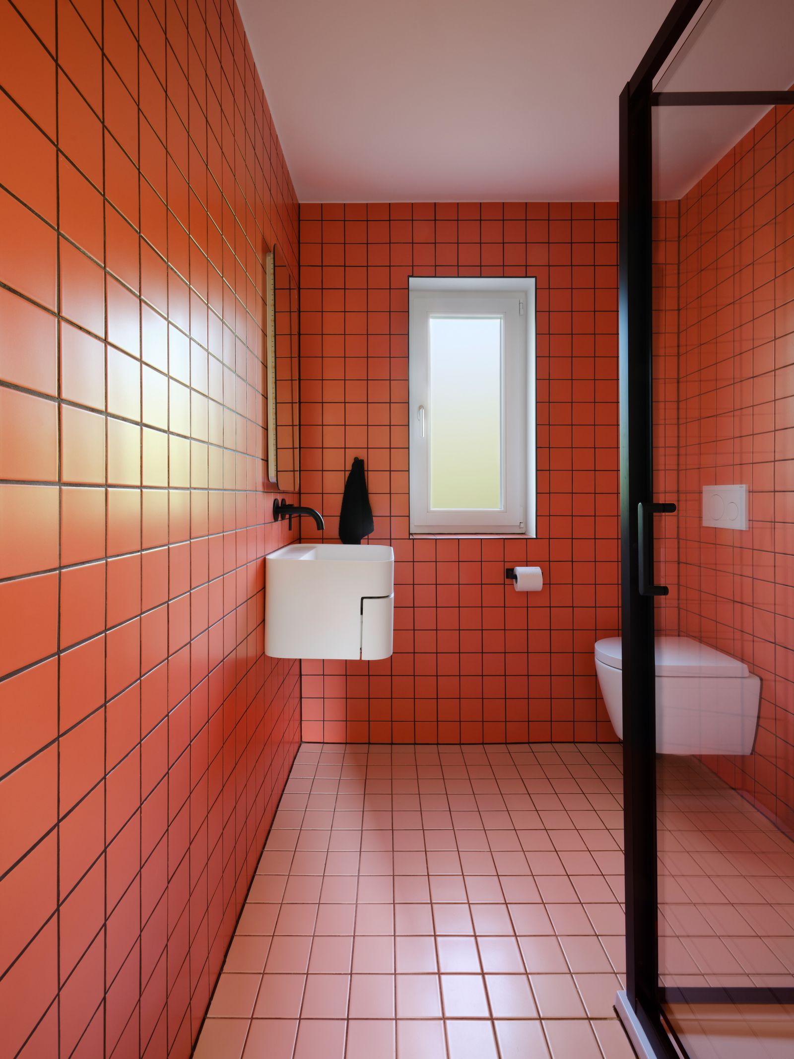 Der Boden und die Wände des kleinen Bads sind rot gefliest.