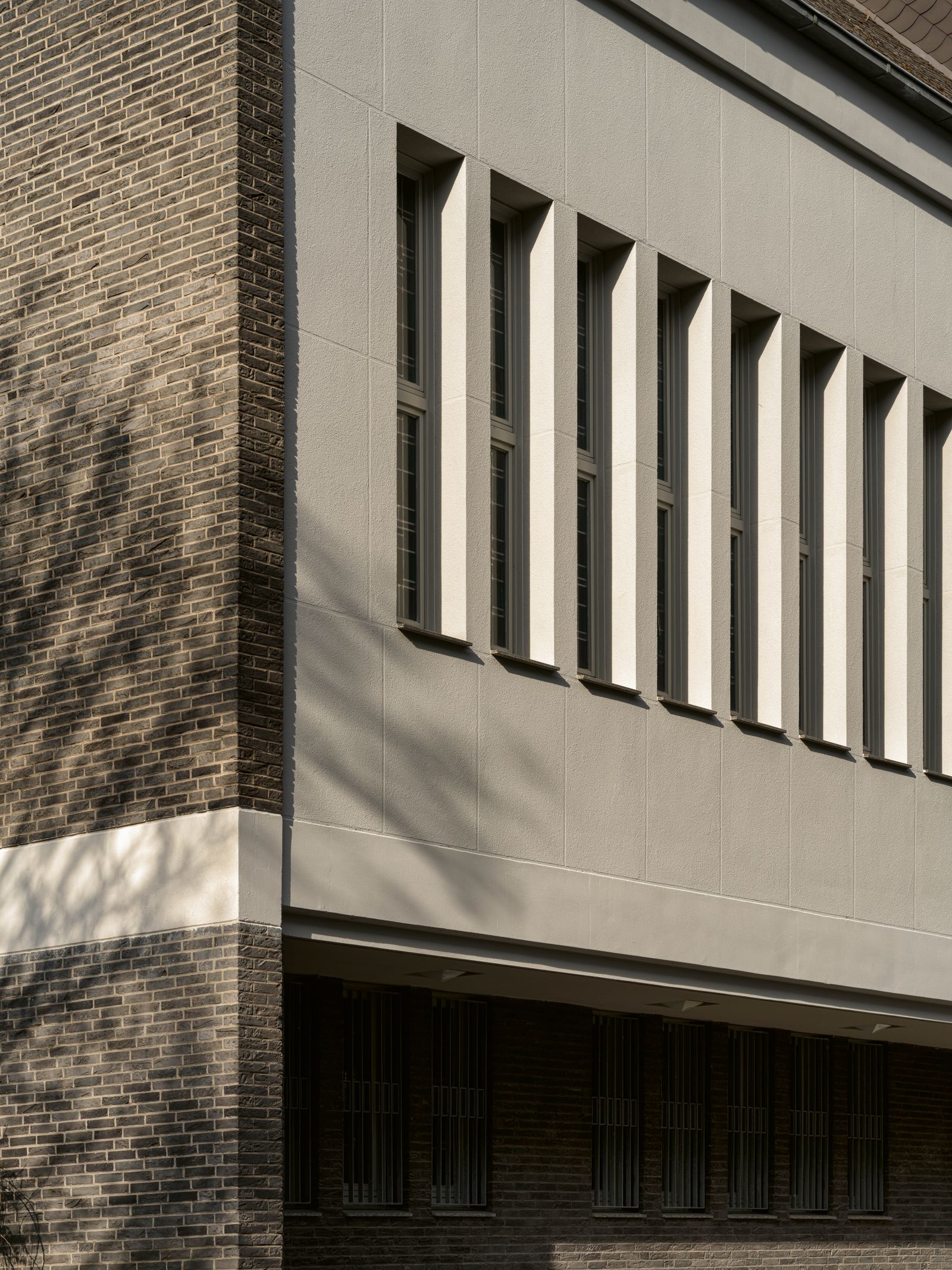 Die Fassade der Kirche mit schmalen Buntglasfenstern
