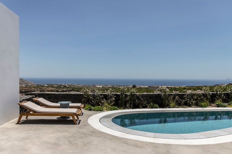 Die Gestaltung setzt auf lokale Materialien wie Stein und Holz sowie eine schlichte Farbpalette aus Weiß Ocker und Grau.